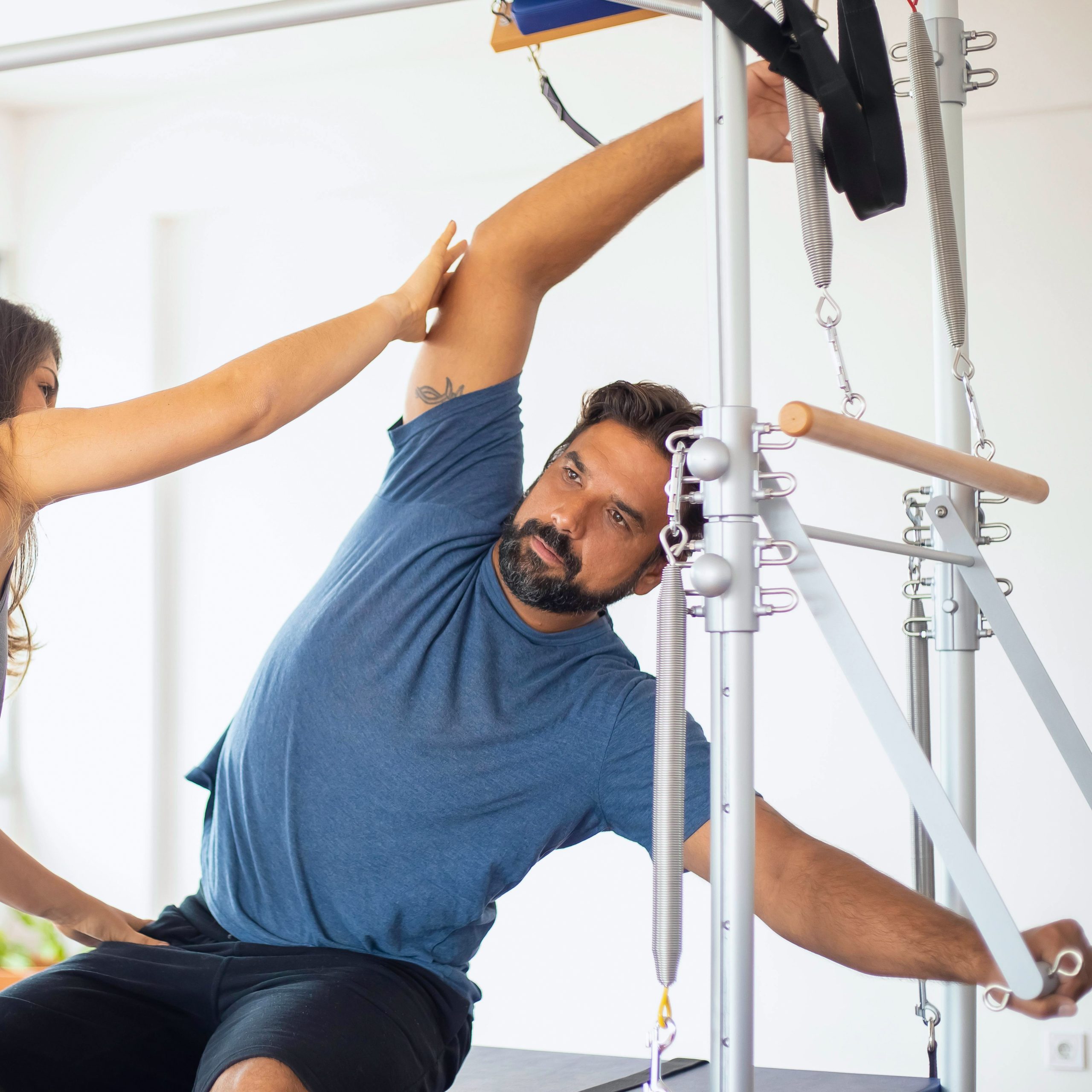A man stretching with the aid of a physical therapist.