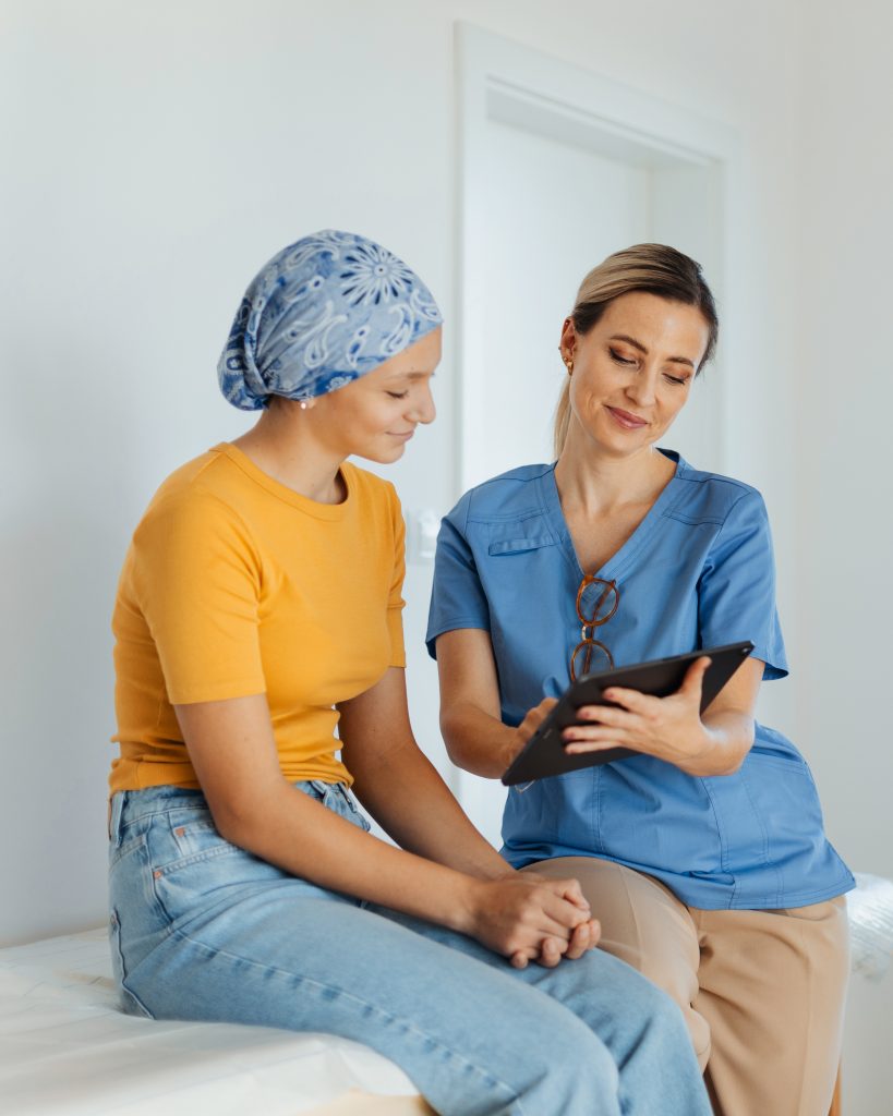 A patient wearing a bandana on her head having a discussion with a physical therapist.