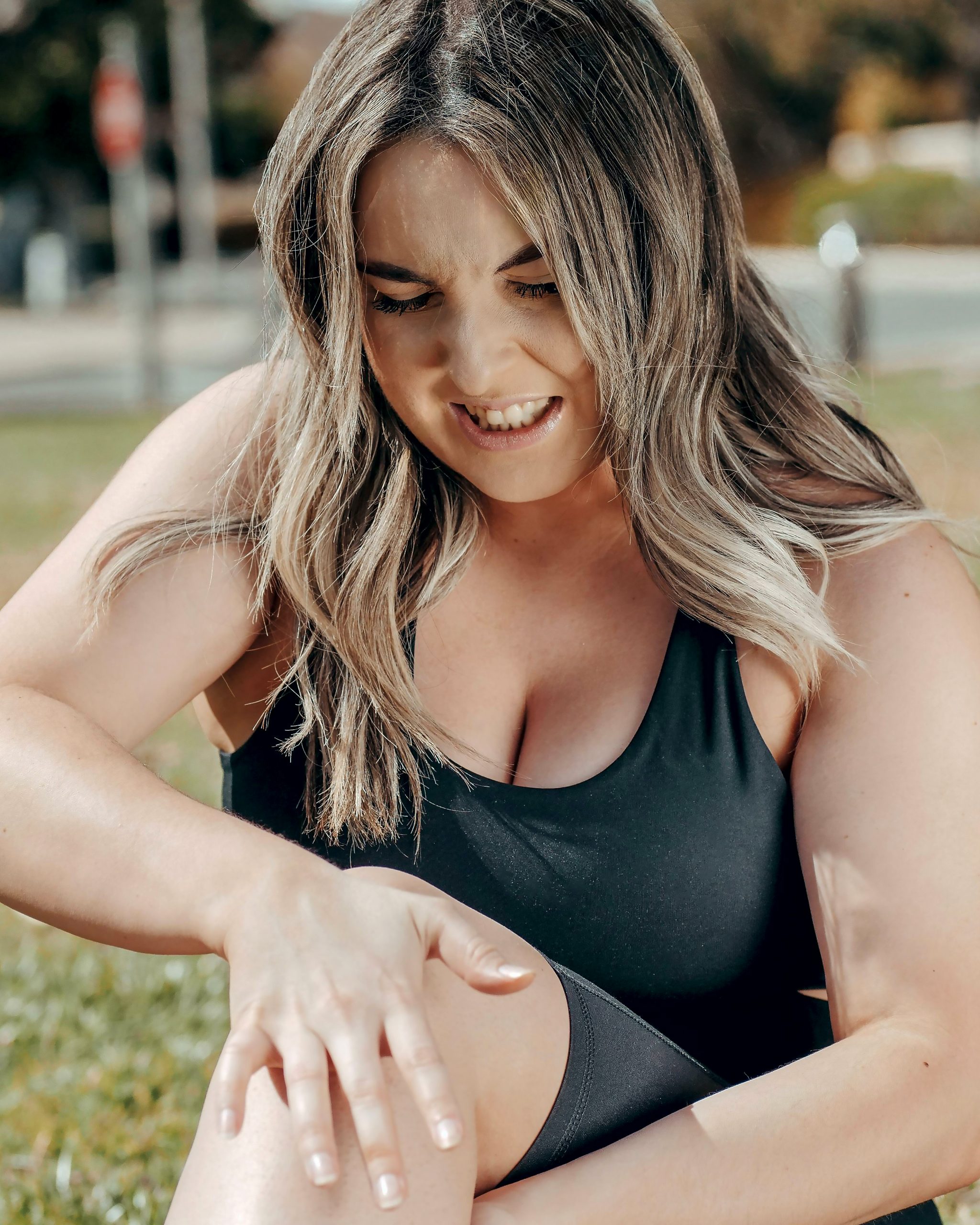 A woman holding her knee in pain. 