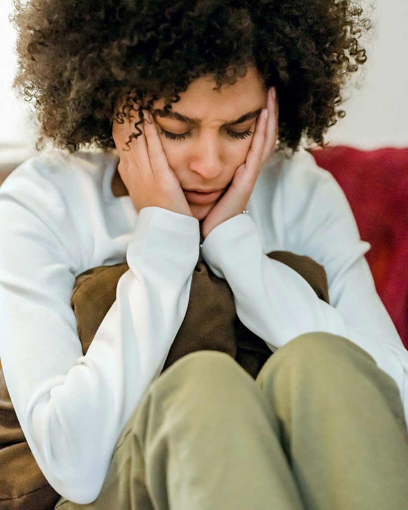 A woman holding her jaw in pain.