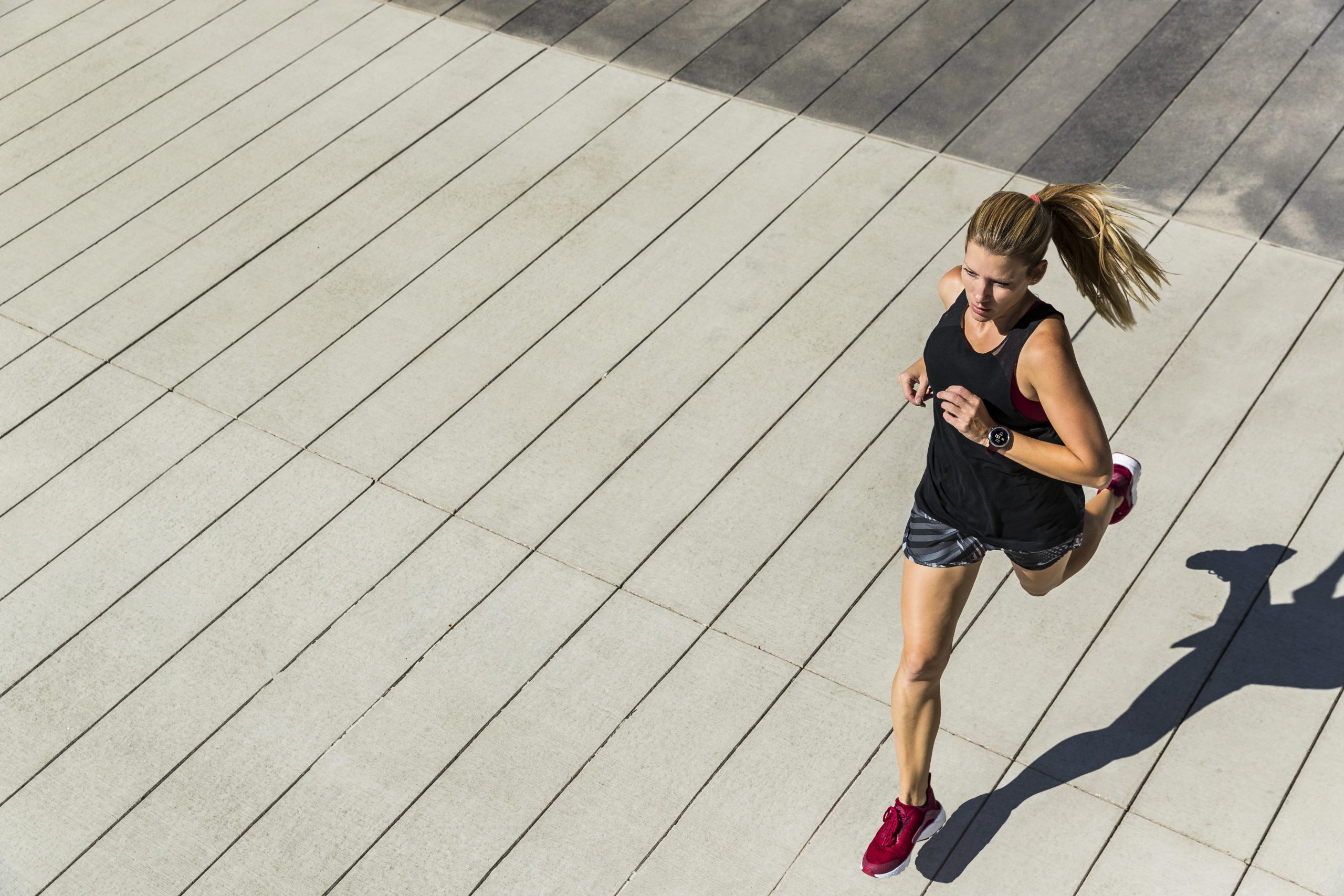 woman running on a wooden boardwalk.
