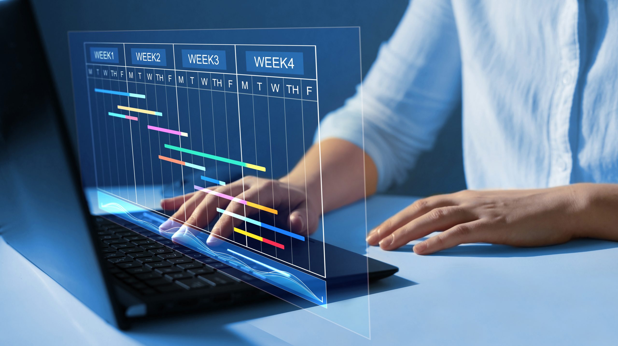A person sitting at a computer with a scheduling form on the screen. 